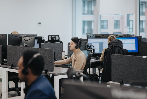 Employees sitting in the open office at their workstations