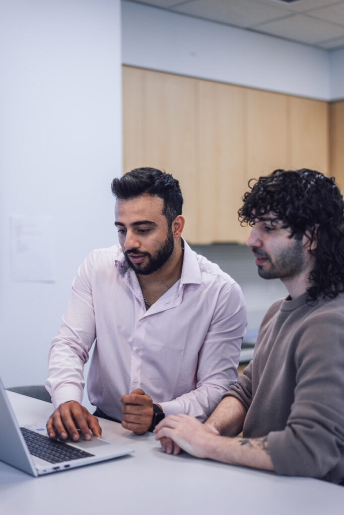 Two coworkers working on a laptop