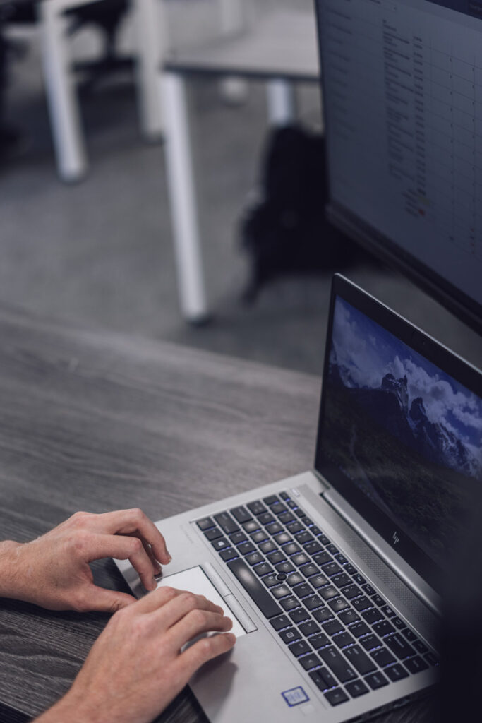 Hands typing on a laptop keyboard