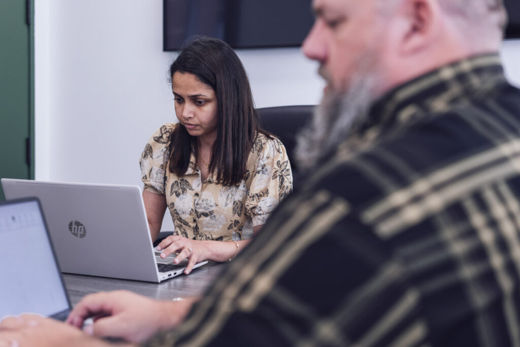 Employees working on laptops in the boardroom