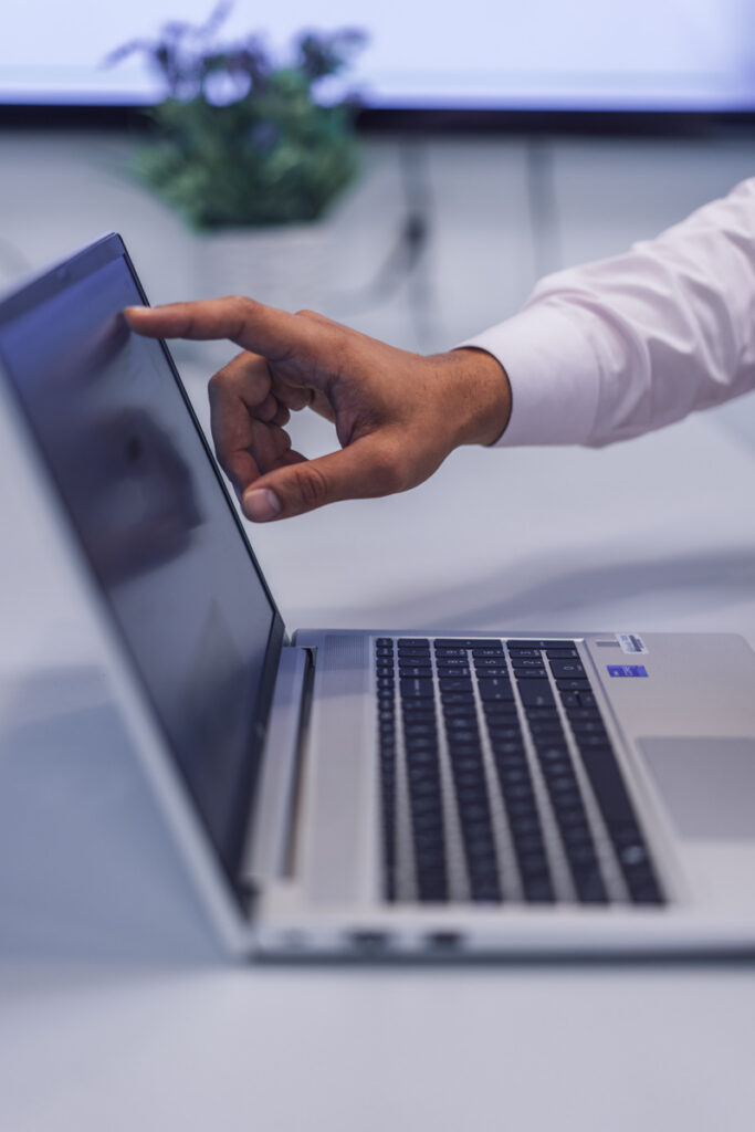 A finger pointing at a laptop screen