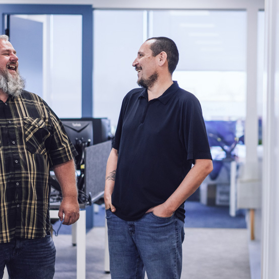Two employees chatting and laughing in the office