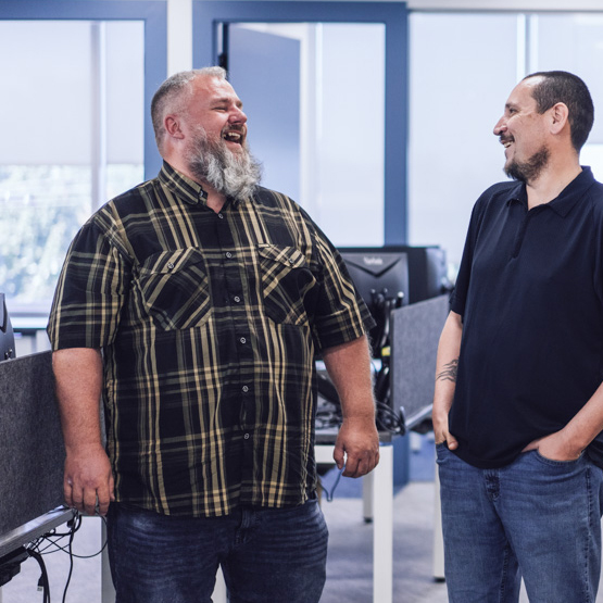 Two employees standing and laughing in the office